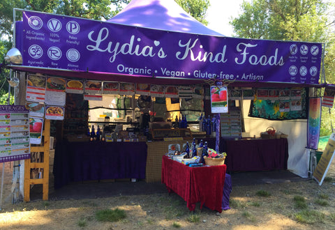Lydia's Kind Foods stand with custom banner.