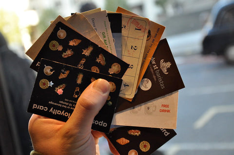 A hand holding coffee loyalty cards. 