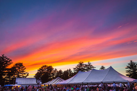 Colorful sunset over festival tents. 